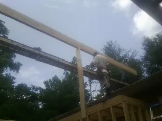 Carpenter setting a ridge beam over a new addition frame — Ice Dam Removal by Roofing Brothers in Hacienda Heights