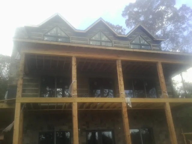 Dormers and porch framing on a large log home under construction — Roof Coating work by our crew in Hacienda Heights