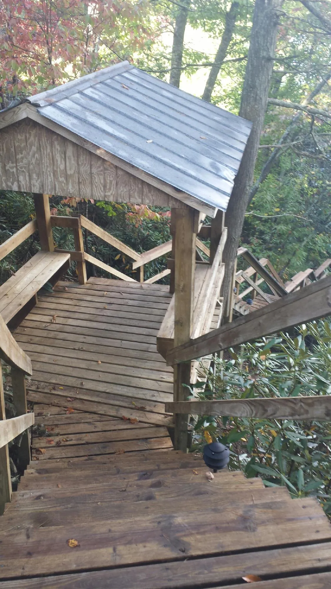 Metal roofed shelter over wooden steps on a wooded walkway — Skylight Repair & Installation work by our crew in Hacienda Heights